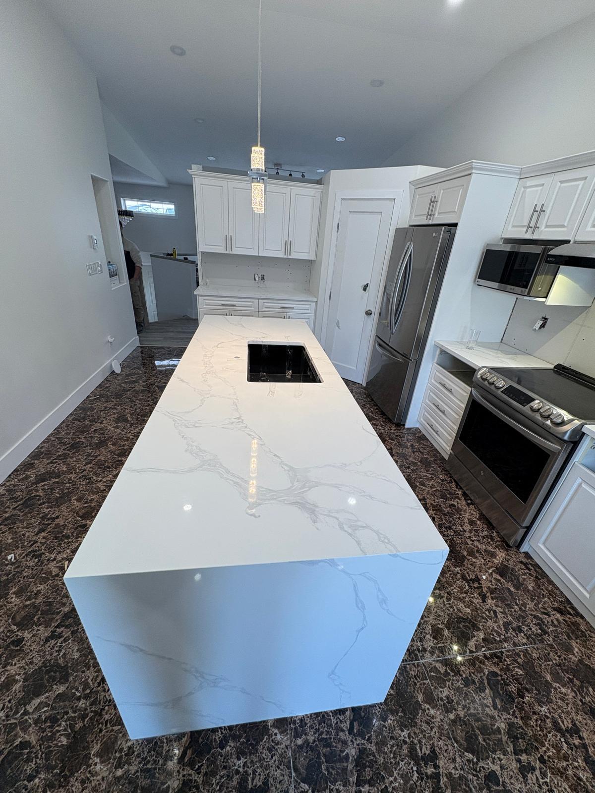 White calacatta quartz kitchen island with undermount sink installed in a Calgary home