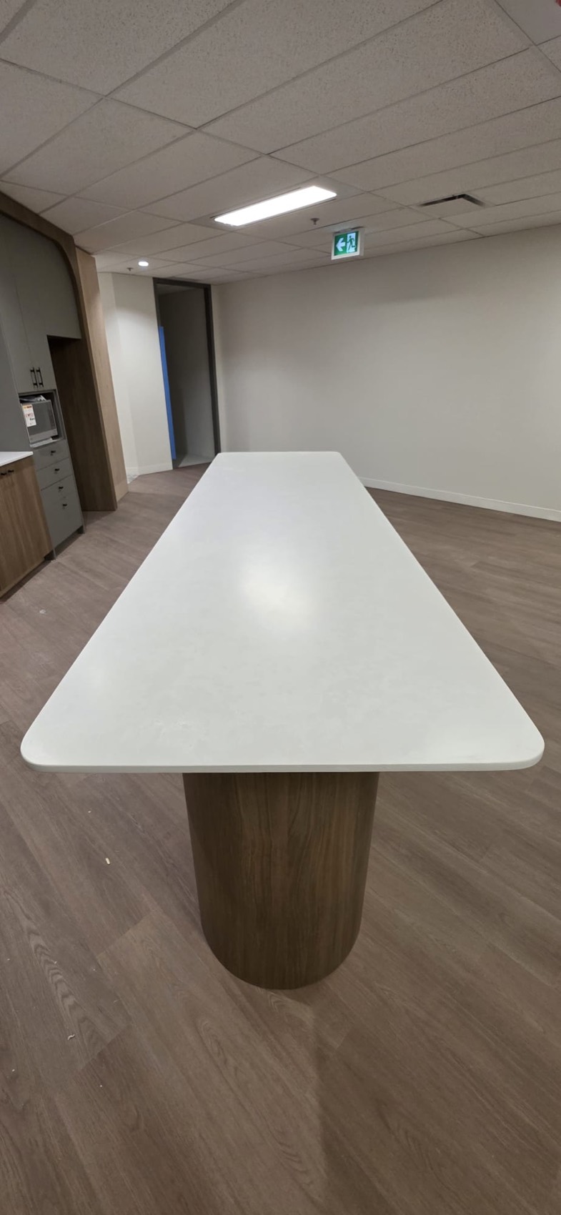 Long white stone table on a rounded base, Calgary install by Bedrock Countertops