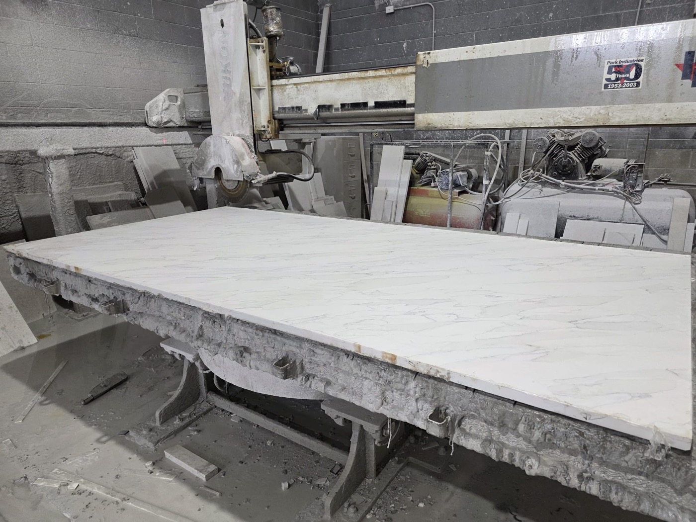 Marble slab being measured and cut in Bedrock Countertops' Calgary fabrication shop
